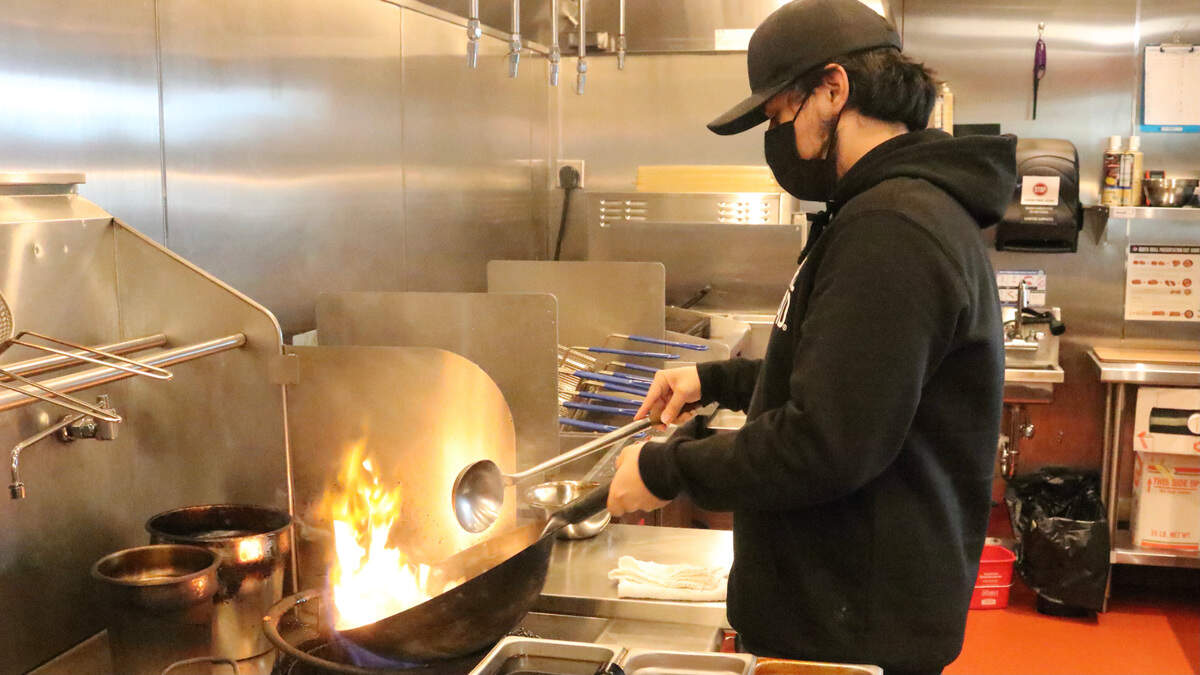 01/19/2021--A cook cooks up stir fry at Bento Asian Kitchen + Sushi, which opened recently in Unit 5 of 190 N. Cattlemen Road in the University Town Center.