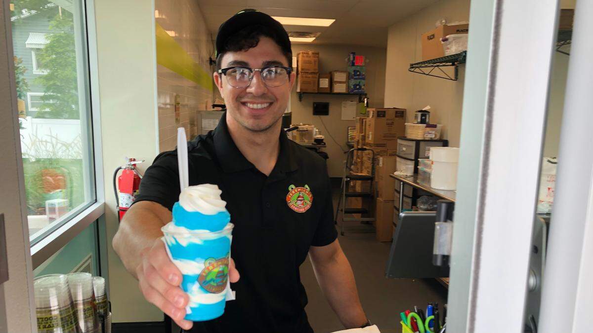 6/18/2021--Jake Lopez serves a Blueberry Gelati, made of swirls of Italian ice and soft ice cream, at Jeremiah’s Italian Ice, 2525 Manatee Ave. W. The store opens Tuesday, June 22.