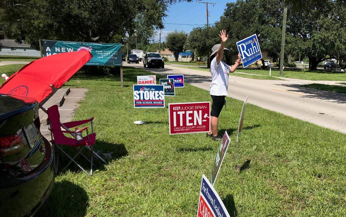 Ana Rivas was waving a sign for circuit judge candidate Maria Ruhl outside Precinct 101 in Church of Hope, Palmetto, on Tuesday.
