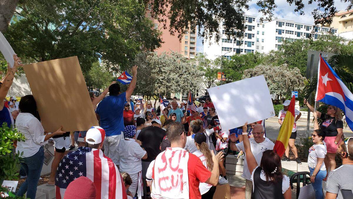 Protesters singing the Cuban national anthem in downtown Sarasota as they rallied and marched on Saturday calling for American intervention in Cuba to give the country freedom from the totalitarian communist dictatorship.