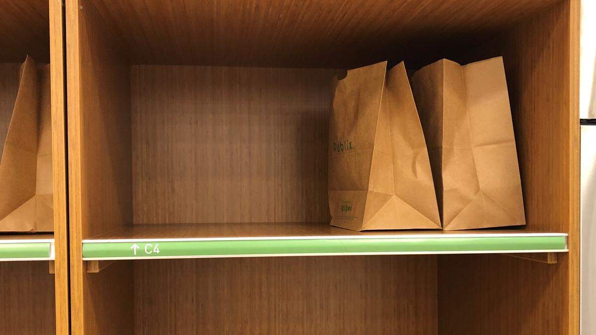 Groceries collected by Instacart shoppers are placed in bins, awaiting pickup by customers. Instacart also offers home delivery.