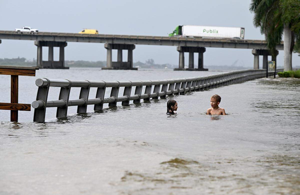 Willow and Teddy Baxter, 6 and 7 years old, swim in the floodwaters on Bradenton’s Riverwalk after Hurricane Idalia passed on August 30, 2023.