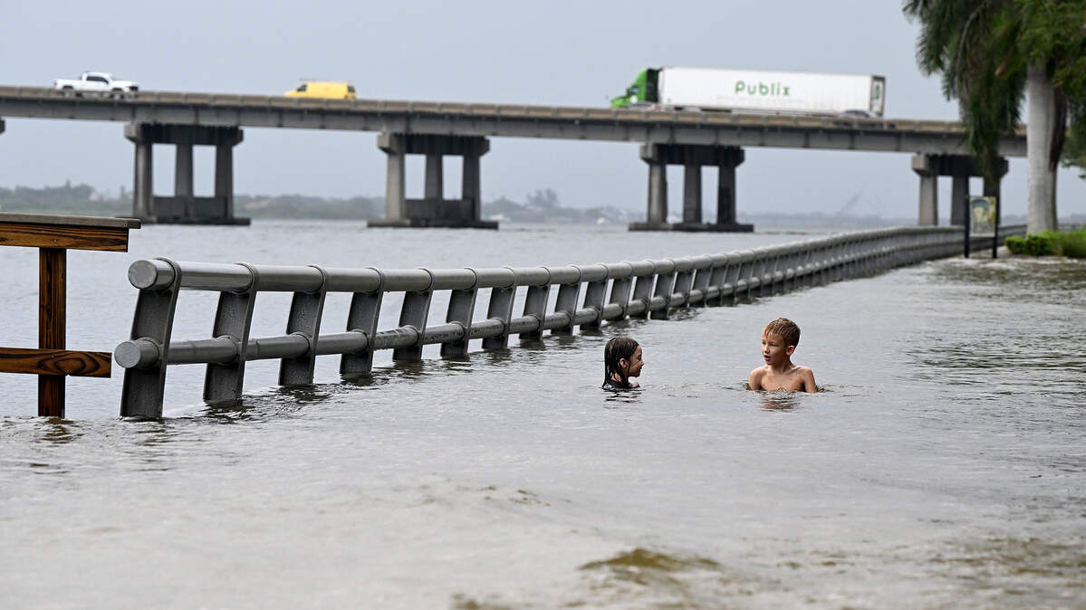 Willow and Teddy Baxter, 6 and 7 years old, swim in the floodwaters on Bradenton’s Riverwalk after Hurricane Idalia passed on August 30, 2023.