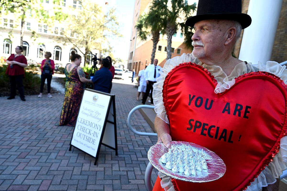 ‘Joe Kisses’ greeted people attending a group wedding ceremony with Hershey’s kisses beside the Historic Manatee County Courthouse on Feb. 14, 2024.