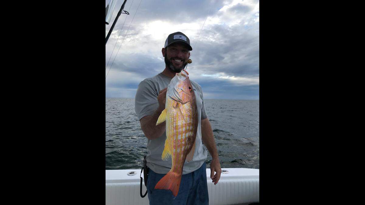 Capt. Josh Bibler shows off a lane snapper caught fishing on a ledge in 70 feet of water.