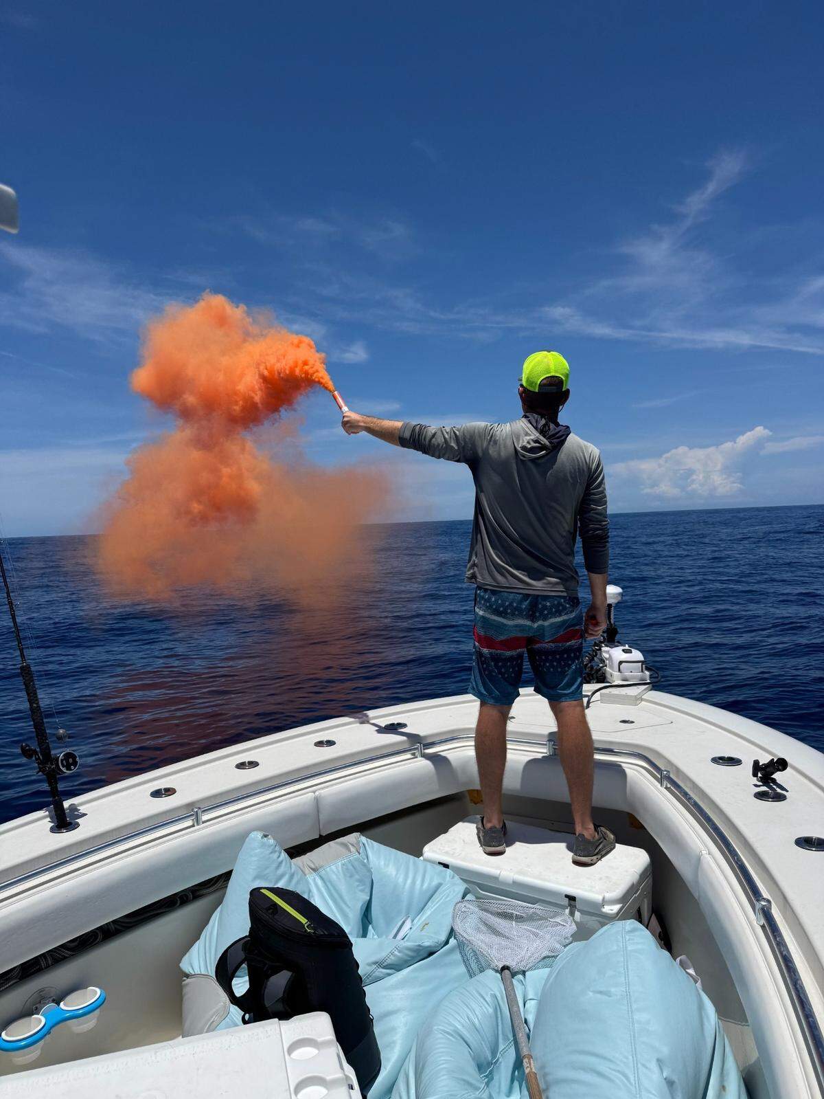 Jon Chapman stands at the bow of a boat that died 60 miles offshore, holding a smoke flare to get the attention of a nearby boat that eventually came to the rescue.