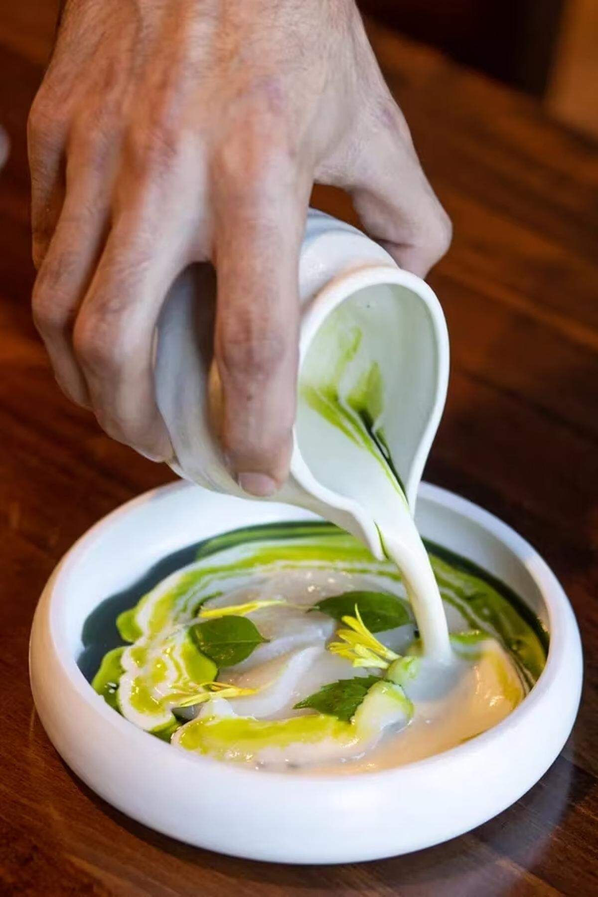 A raw scallop dish at Meliora is warmed by a hot scallop cream poured tableside.