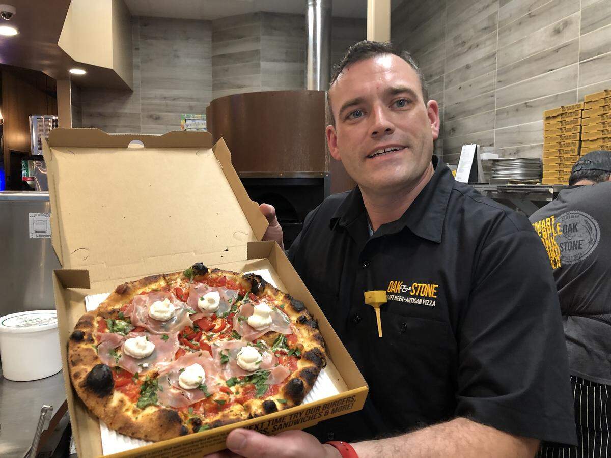 Rob Lauterbach, general manager of the new Oak & Stone Fastfire restaurant in Bradenton, boxes a freshly baked pizza. Fastfire is a new concept for the Sarasota-based company.