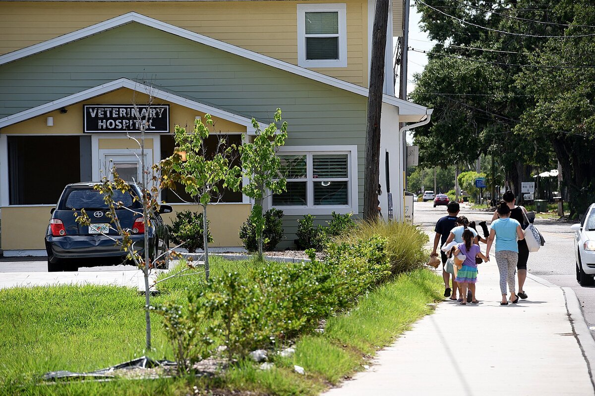 A family walks past the new Veterinary Hospital on 14th Street West.