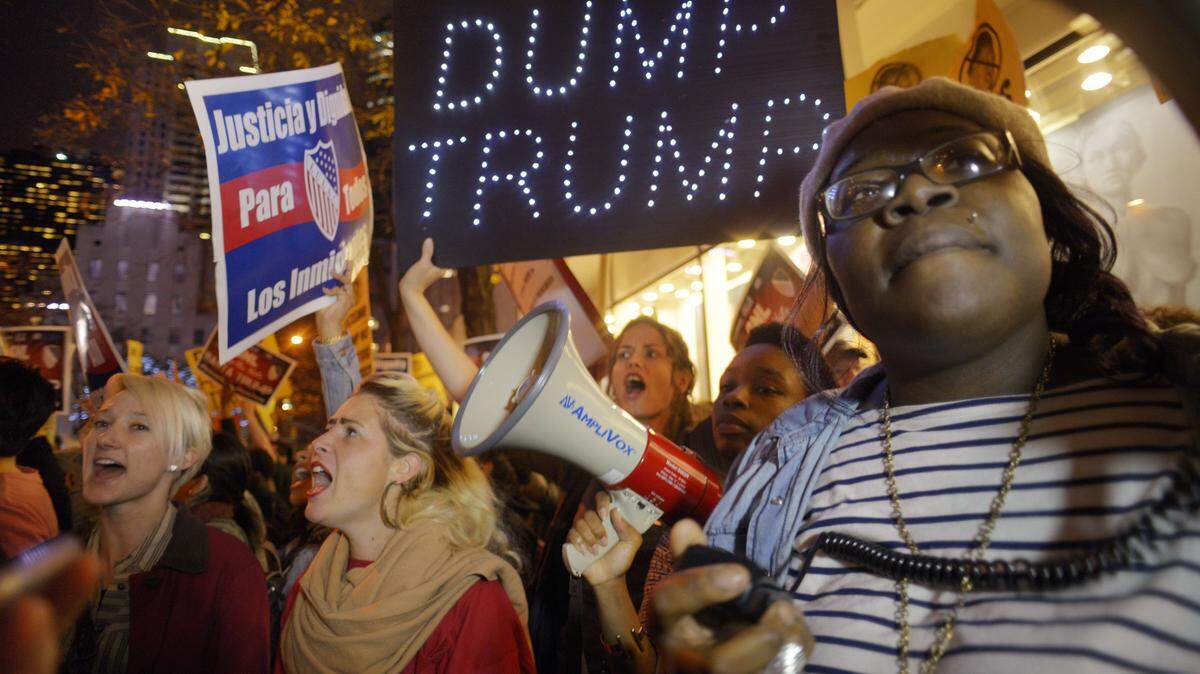 Sasha Murphy, of the ANSWER Coalition, leads demonstrators in a chant during a protest against Republican presidential candidate Donald Trump's hosting "Saturday Night Live" in New York, Saturday, Nov. 7, 2015. Despite a 40-year history of lampooning politicians while inviting some to mock themselves as on-air guests, booking a presidential candidate to host the NBC sketch-comedy show is almost unprecedented. (AP Photo/Patrick Sison)