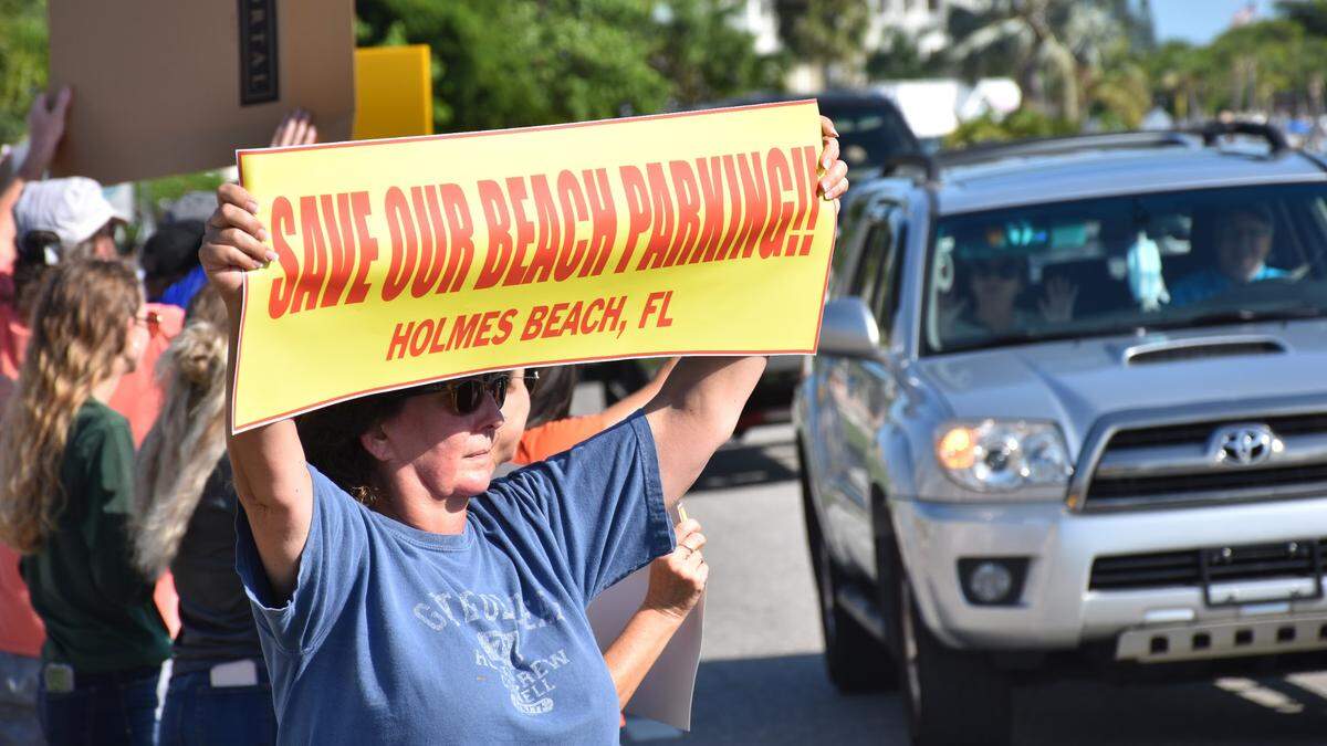 More than 80 residents and visitors stood outside Holmes Beach City Hall, 5801 Marina Drive, Tuesday evening to protest the city’s new beach access parking plan, which removes 1,100 spaces that are within a quarter-mile of the beach.