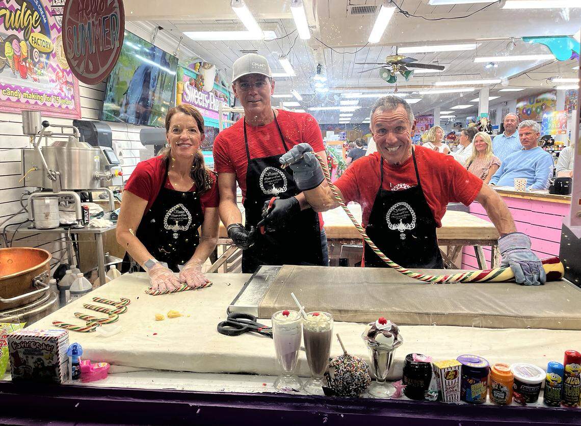 Tamela Behm-Vrinios, Mark Napier and Peter Vrinios display the candy canes made atop his family’s antique candy table at the Fudge Factory in Bradenton Beach. Vrinios’ family has been making candy for four generations and has been putting on a candy show during the holidays.