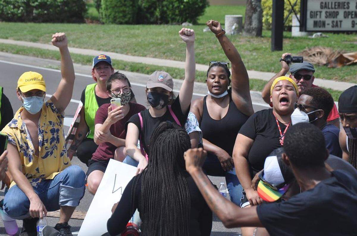 Protesters kneel in the middle of the intersection of Ninth Street West and Third Avenue West in downtown Bradenton during a march to protest the death of George Floyd in Minnesota.