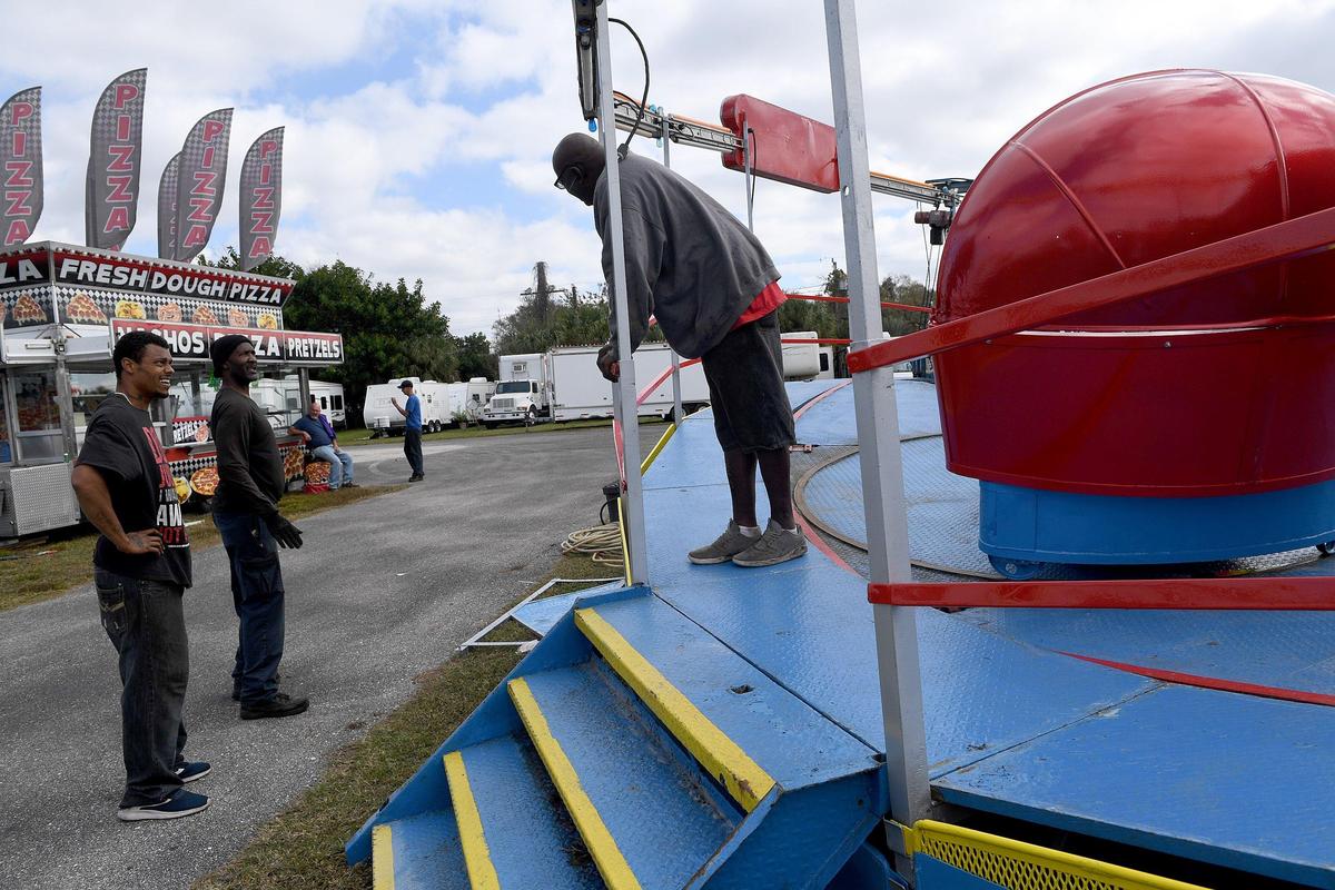 Workers get the Tilt-A-Whirl set up for the annual Manatee County Fair at the fairgrounds in Palmetto.