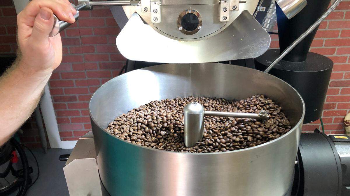 Roasted coffee beans go into a cooling tray before they are packaged in Banyan Coffee Company bags for delivery to customers.