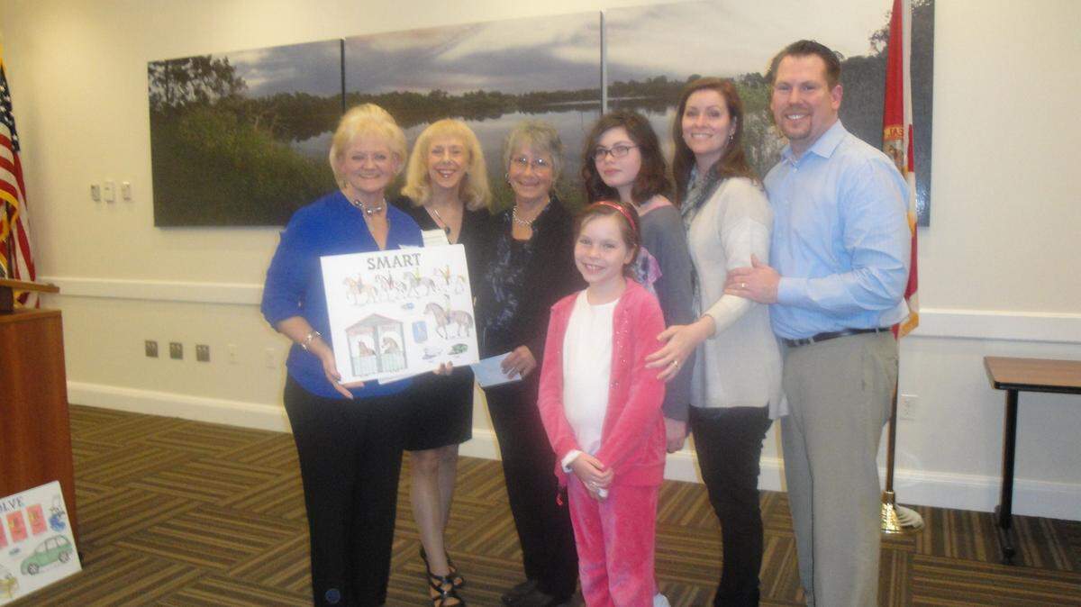 On Jan. 14, the Lakewood Ranch Women's Club recognized their 2015 adopted charities at their January Business Meeting at the LWR Town Hall. They are HOPE Family Services, SOLVE Maternity Homes and SMART. From left, Nancy Wozniak, LWRWC Philanthropy Chair; and Monika Templeman, LWRWC Vice President/Publicity and Event Chair; present a $10,000 check to Gail Clifton, Executive Director, SMART; and the Martin Family - Delaney (in front), Kennedy, Kerri and Scott. 
 PHOTO PROVIDED