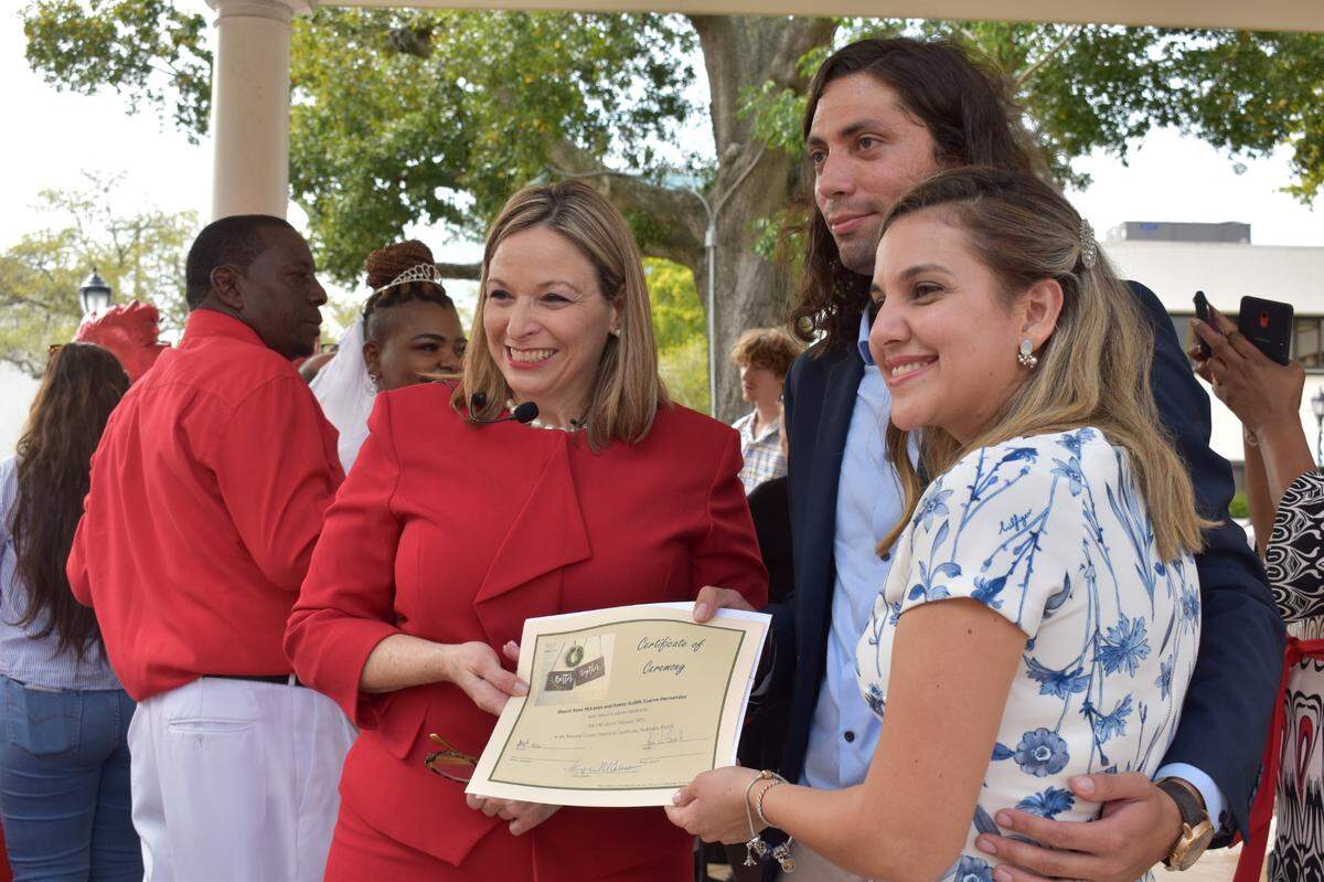 Manatee County Clerk of Court Angel Colonneso takes a picture with couple and their marriage certificate after the Valentine’s Day group wedding ceremony on Feb. 14, 2022.