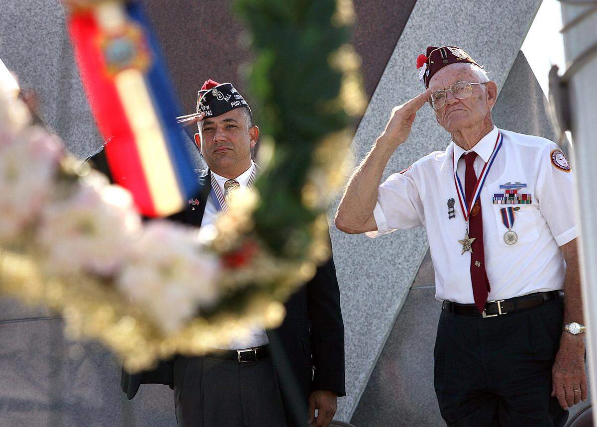 Retired Gy/Sgt. Greg Witham and Robert Eldridge salute during a Memorial Day service at the Veteran’s Monument in 2008.