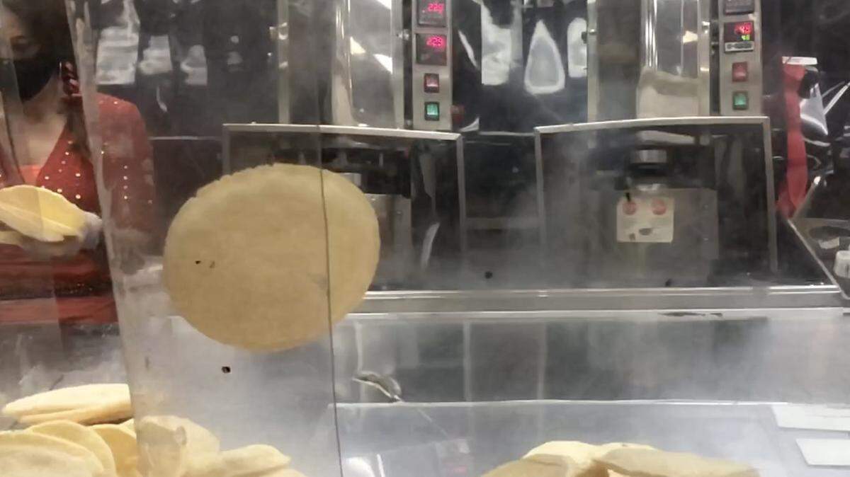 2/10/2021--A piping-hot Broghie flies out of the Broghie machine at Mixon Fruit Farms. Mixon is now the U.S. distributor for the popped grain wafers.
