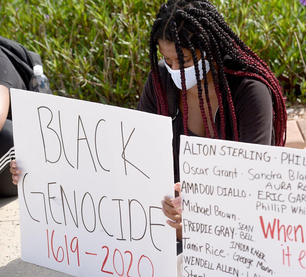 A protest organized by Matthew Garcia was held at Bradenton’s Riverwalk Monday morning. Taylor Jackson kneels and holds a sign during the peaceful march.