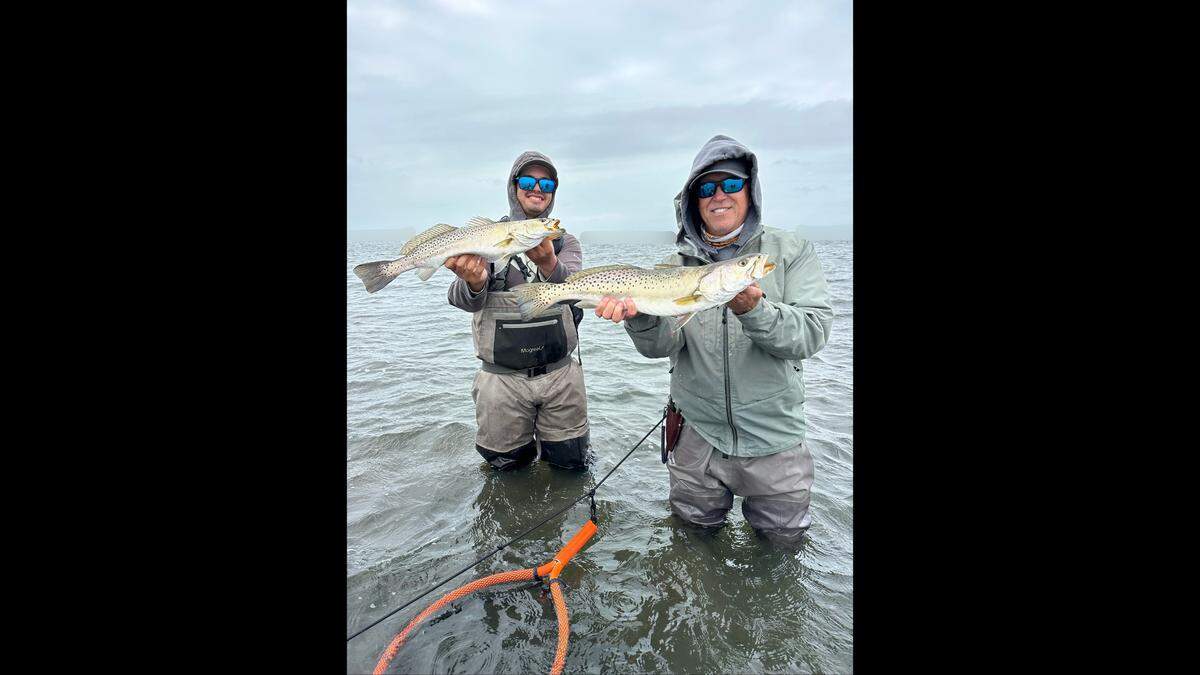 Anglers pose with redfish caught while wading Tampa Bay flats in 60-degree water with Captain Peter Smith.