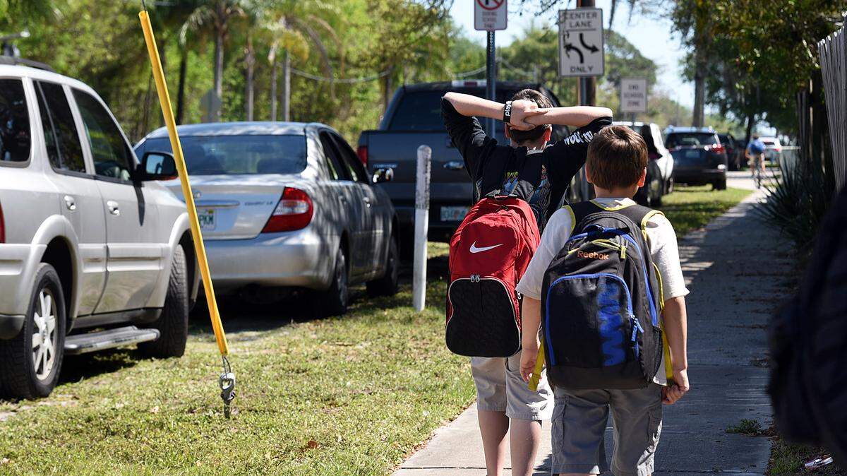 King Middle School students head toward a line of cars parked along 75th Street near the school where parents pick up their children. A council of governments meeting will discuss parking and traffic issues in the area.TIFFANY TOMPKINS/Bradenton Herald