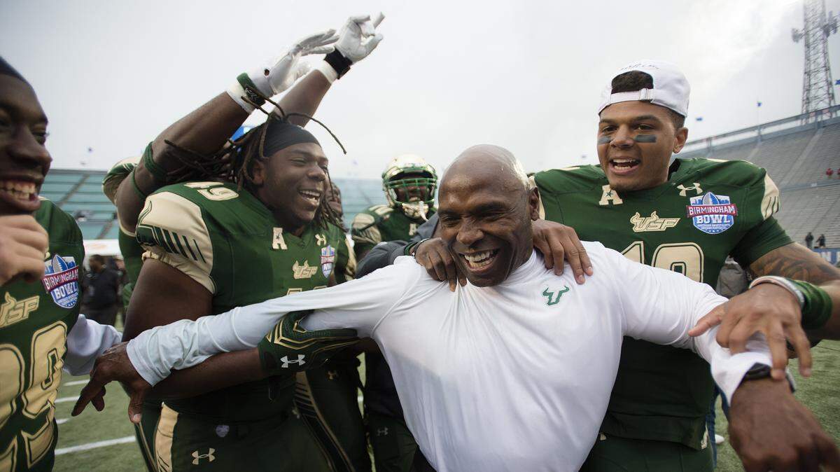 South Florida quarterback Chris Oladokun (10) and tight end KJ Miles (49) celebrate with head coach Charlie Strong after the Birmingham Bowl NCAA college football game, Saturday, Dec. 23, 2017 in Birmingham, Ala. South Florida won, 38-34.