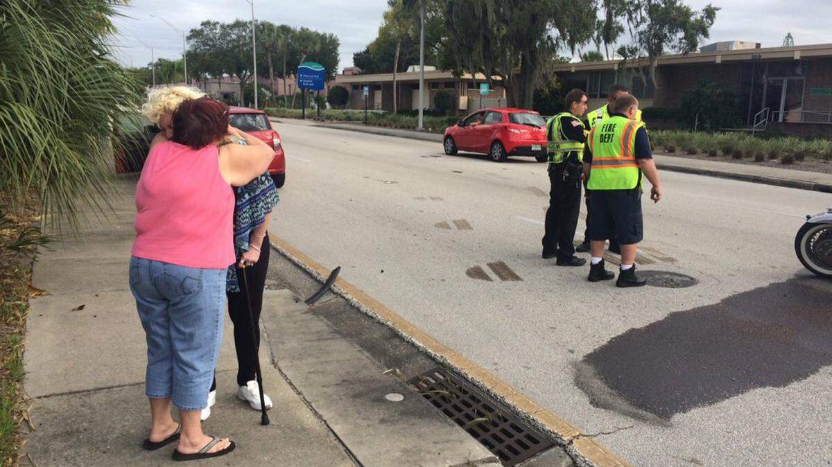 A woman is comforted by another woman Friday afternoon at the scene of a vehicle vs. motorcycle crash in Bradenton. 
 AMARIS CASTILLO/Bradenton Herald