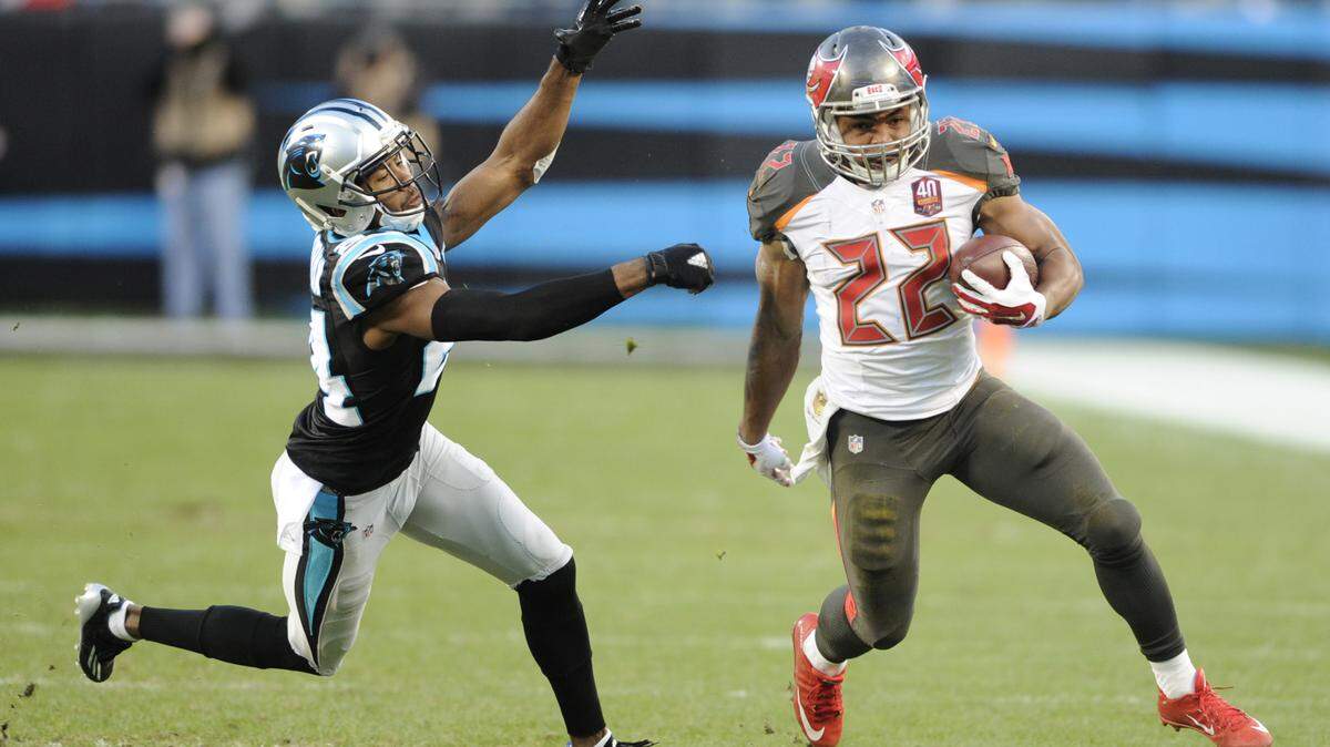 Tampa Bay Buccaneers running back Doug Martin (22) runs as Carolina Panthers cornerback Josh Norman (24) pursues in the first half of an NFL football game in Charlotte, N.C., Sunday, Jan. 3, 2016. (AP Photo/Mike McCarn)