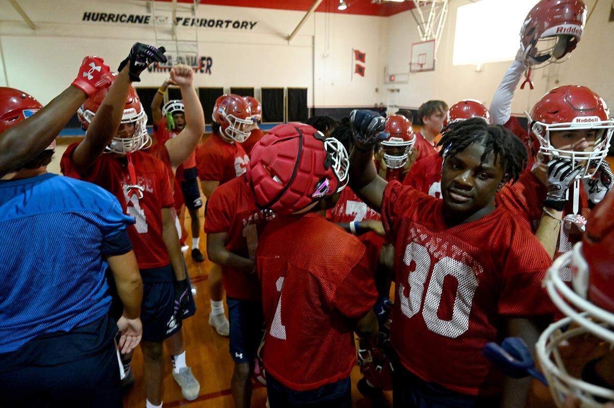 The Manatee Hurricanes High School football team practice indoors in the JROTC gym on the campus as the heat index pushed 94 outside. The team gathers at the end of practice.