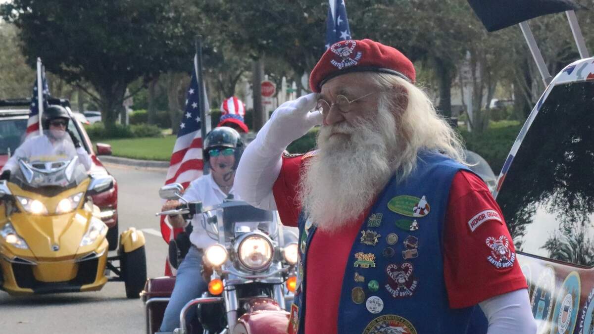 Steve Hadala of the Santa Claus Drill Team stopped to salute Retired Navy Lt. Cmdr. Roger Quisenberry, a World War II veteran, on his 100th birthday.