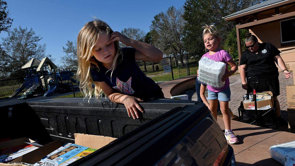 Bailey, 6, and Bristol Bigi, 4, load supplies for families impacted by Hurricane Ian at the Myakka Community Center October 7, 2022.