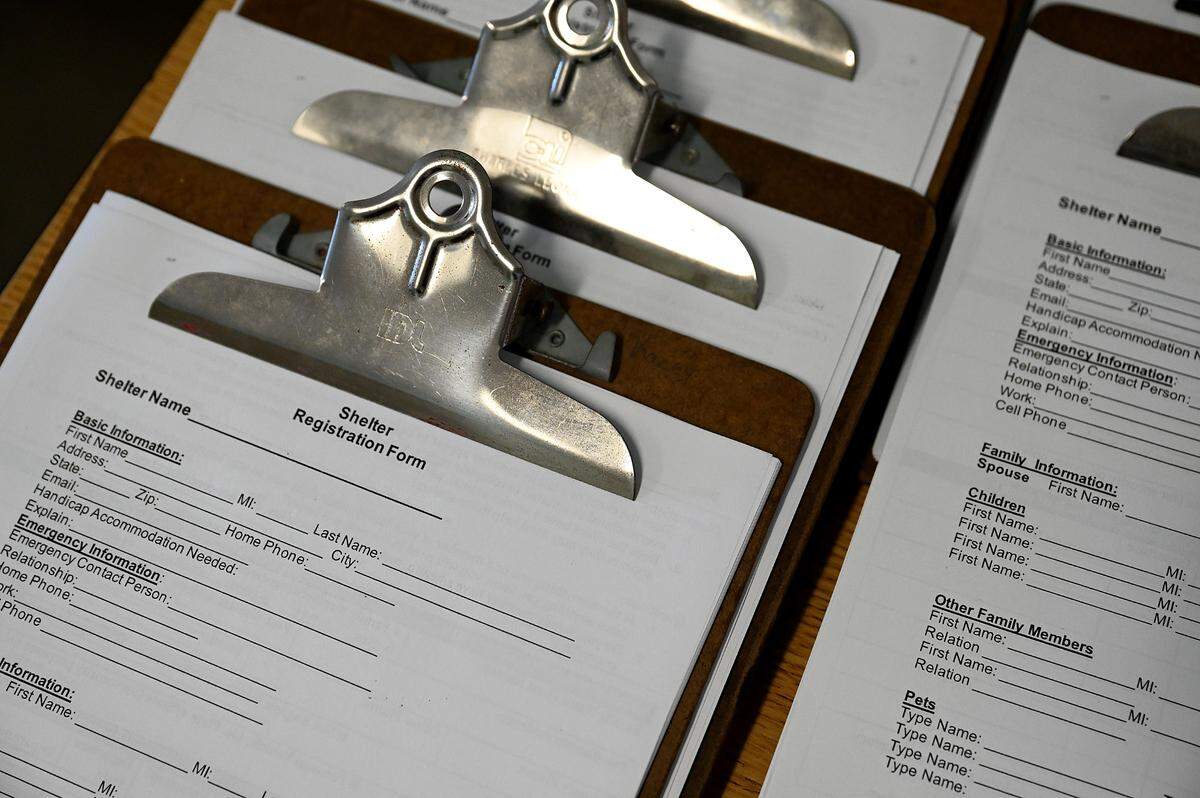 Clipboards with registration paperwork are lined up for residents to check in to the shelter at Jesse P. Miller Elementary School in preparation for Idalia’s expected strengthening and approach on August 28, 2023.
