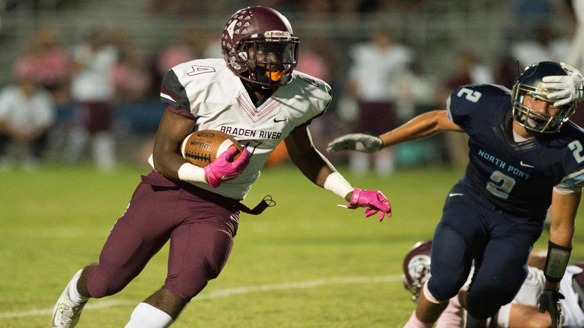 Braden River's Raymond Thomas beats North Port's Jon Cruz around the end for a first quarter touchdown Friday at North Port. JOHN KERSTEN/Sun Coast Newspapers