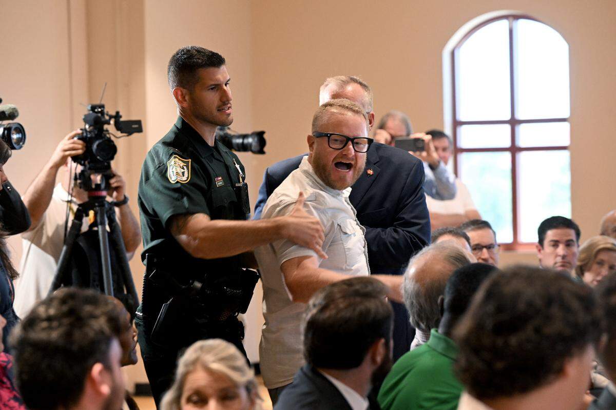 A protester disrupted a press conference while Florida Governor Ron DeSantis spoke at the Manatee Performing Arts Center in Bradenton on July 24, 2025.