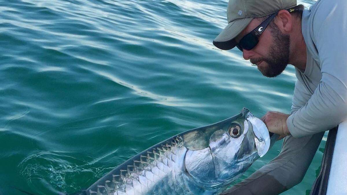 Captain Jason Wightman holds a tarpon. He runs a charter fishing business called Grande Tarpon Charters out of Palmetto.
