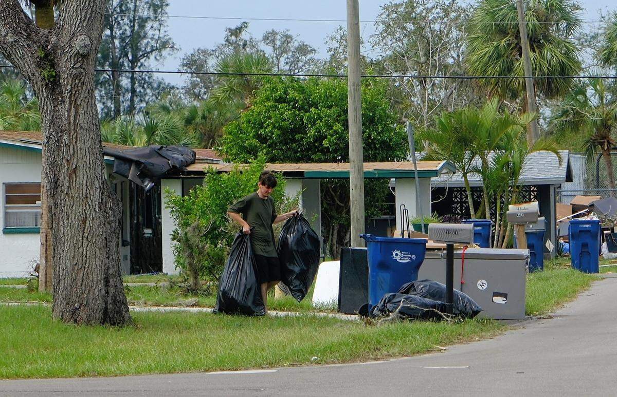 10-11-2024--Dylen White piles storm debris at his curb in Rubonia after the Manatee County neighborhood was hit hard by back-to-back hurricanes.