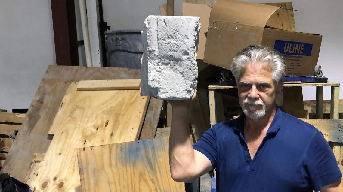 Paul Falco holds a block of lightweight cellular concrete. The material has many construction uses. His company is located at 5103 Lena Road in East Manatee.