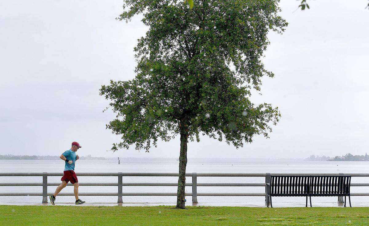 A runner on Bradenton's Riverwalk dodges raindrops as he jogs alongside the Manatee River in mid-May.