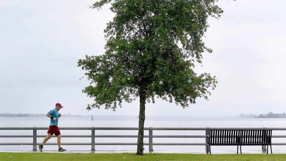 A runner on Bradenton's Riverwalk dodges raindrops as he jogs alongside the Manatee River in mid-May.