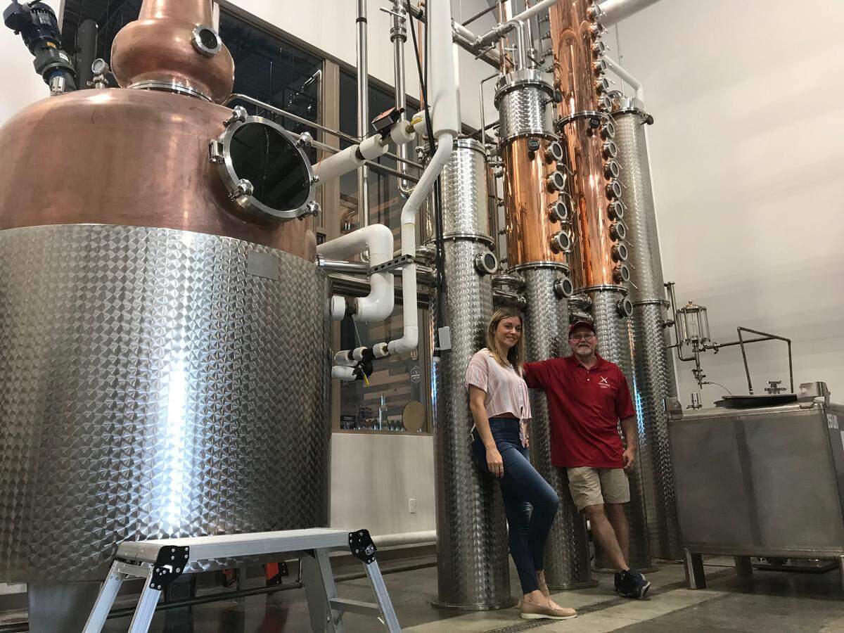 Steve Milligan and Michelle Russell stand with some of the tanks used to make spirits at Loaded Cannon Distillery. The new business opens July 19, at Lakewood Ranch.