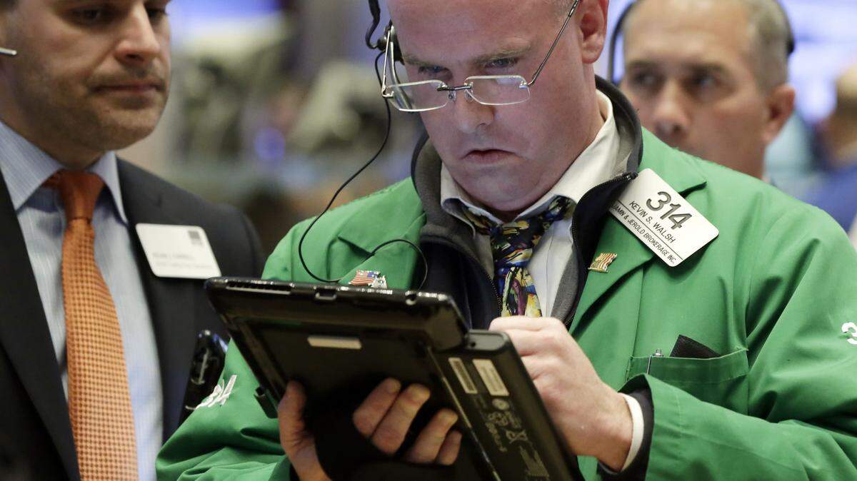 Trader Kevin Walsh works on his handheld device on the floor of the New York Stock Exchange, Wednesday. U.S. stocks recovered much of an early plunge, but the price of oil suffered its worst one-day drop since September.AP Photo/RICHARD DREW