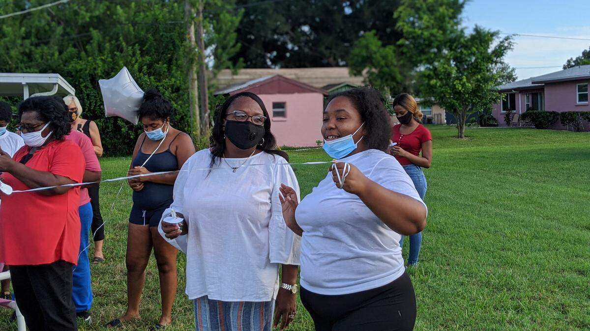 Pastor Belinda Coney, left, and Ciera Morales, right, led a memorial celebration in honor of Ramon Morales, a Palmetto man who died of COVID-19.