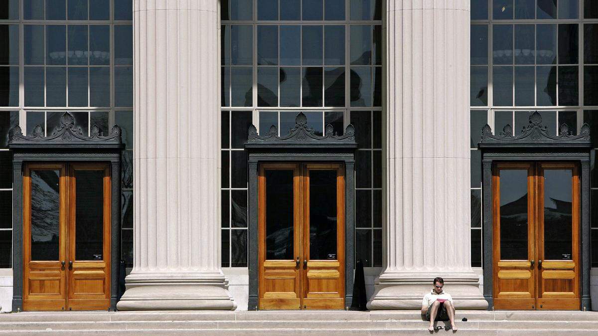 A doctoral student at the Massachusetts Institute of Technology reads outside a building at the Cambridge, Mass., campus in April 2007. MIT is announcing a pilot graduate program and students will take the first part entirely through massive open online courses. Under the plan, students will pay a fee to get course credit, basically taking classes for a fraction of an MIT tuition. ASSOCIATED PRESS