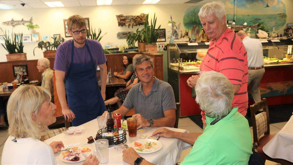 Bryce Bochan, and his father, Captain Brian Bochan, standing, chat with Ines, Chris and Giovanni Lunardi at Captain Brian’s Seafood Market and Restaurant, 8421 N. Tamiami Trail.