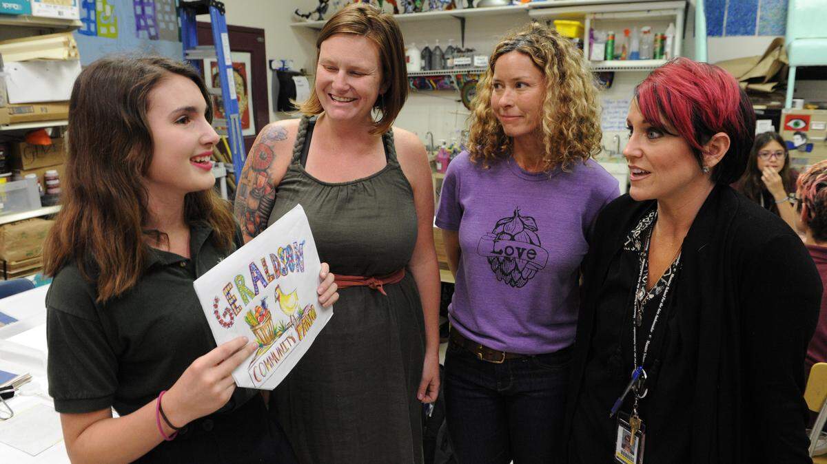 Manatee School For the Arts student Mia Hereford talks about her drawing with Christa Leonard of Geraldson Community Farms, April Gladden, art teacher, and Kelly Hillman, director of marketing at Manatee School For the Arts. Geraldson paired up with MSA to design the exterior of Geraldson's mobile market which will start offering foods in areas of Manatee County this fall. 
 GRANT JEFFERIES/Bradenton Herald