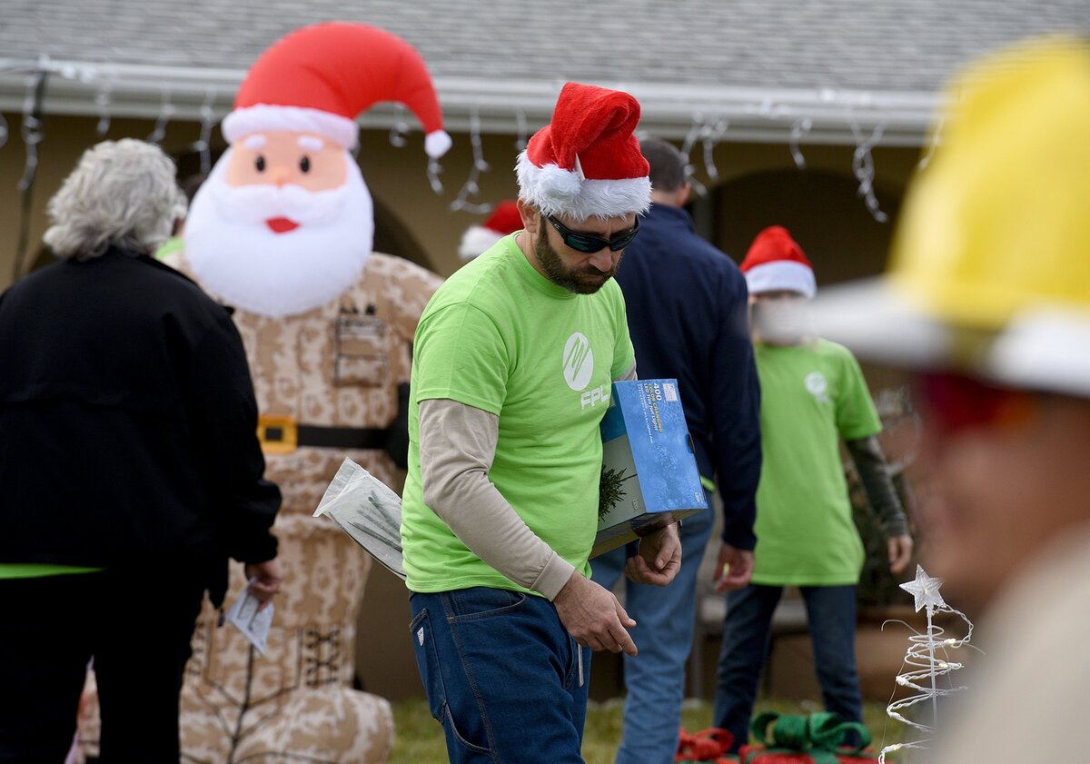 Florida Power and Light volunteers work to decorate and surprise a veteran and his family as a Christmas surprise in Bradenton Monday.