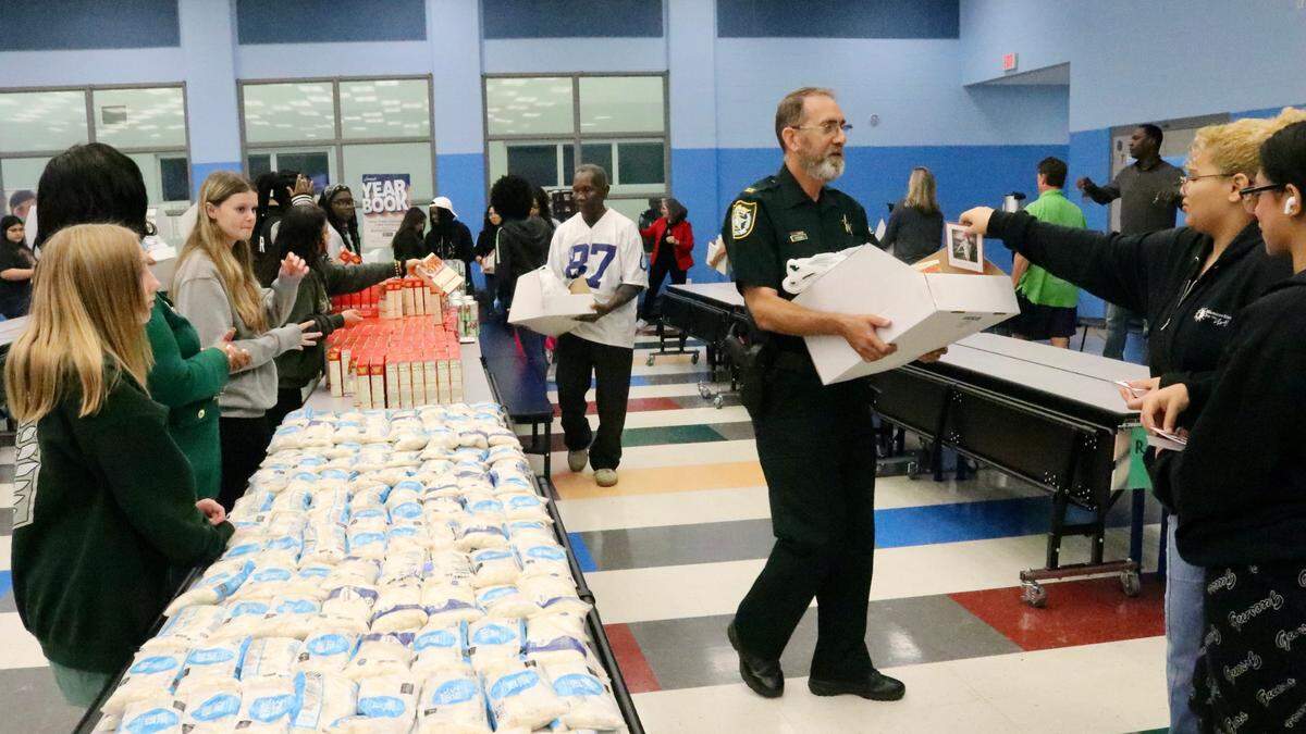 Ian Kogel, shown Nov. 22, 2022, picks up a box of Thanksgiving dinner ingredients to be delivered to a deserving family this week at Lincoln Memorial School. He was one of those helping distribute 400 meals to families this week.
