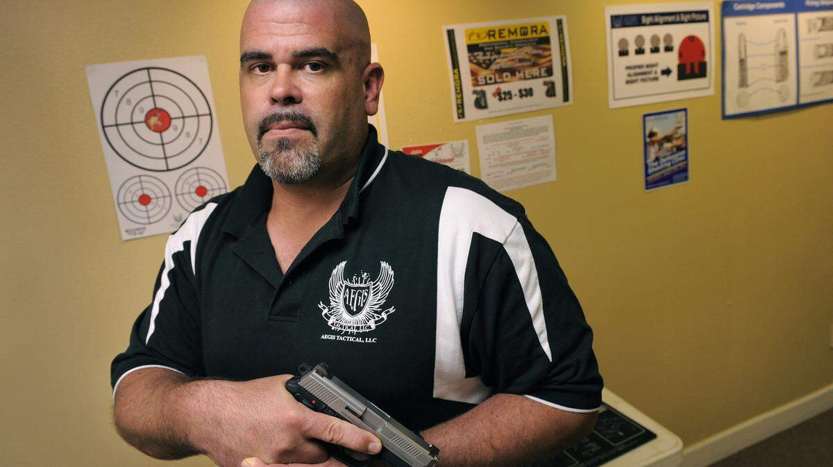 Joe Krawtschenko of Aegis Tactical LLC in Lakewood Ranch holds a .40-caliber FNX handgun.