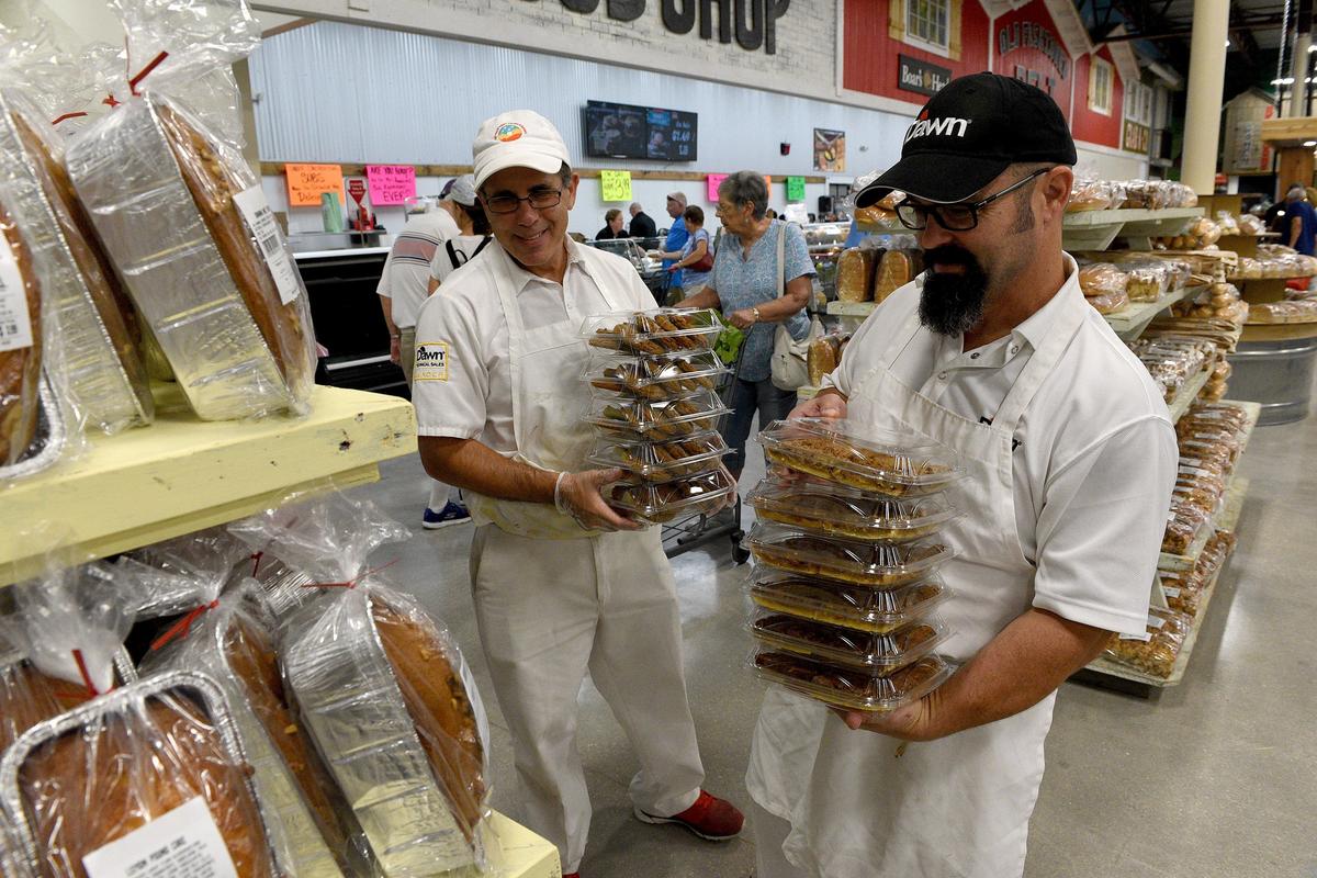 Bakery vendors Adam Katz and Mark Pierce re-stock baked goods at the new Detwiler’s Farm Market in Palmetto.